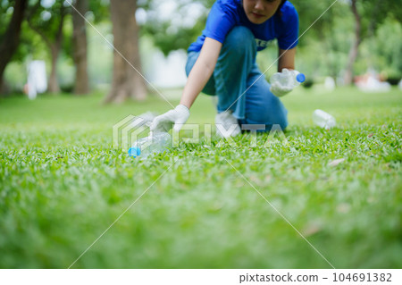 Multiethnic volunteers donate their time holding black garbage bags to collect plastic waste for recycling to reduce pollution in a public park Multiethnic volunteers donate their time holding black garbage bags to collect plastic waste for recycling to reduce pollution in a public park 104691382