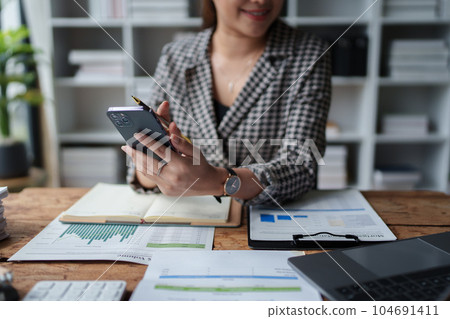 Consultant, Asian businesswoman working on the phone who discussion financial work and marketing business plan to increase company profits, ready to use computer and marketing planning documents. Consultant, Asian businesswoman working on the phone who discussion financial work and marketing business plan to increase company profits, ready to use computer and marketing planning documents. 104691411