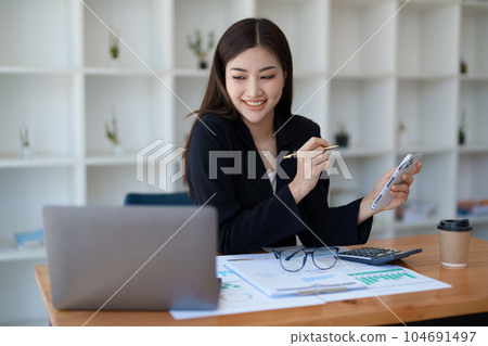 Excited businesswoman using mobile phone while in office , business concepts 104691497