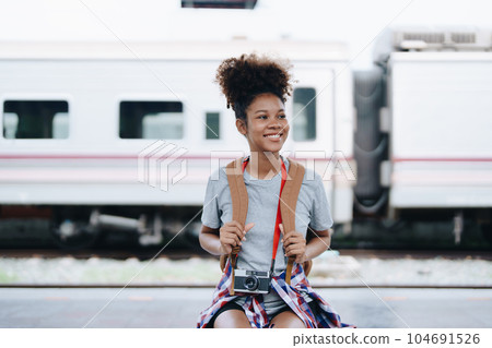 Tourists african american are showing happy expressions while waiting for their journey in the train station Tourists african american are showing happy expressions while waiting for their journey in the train station 104691526