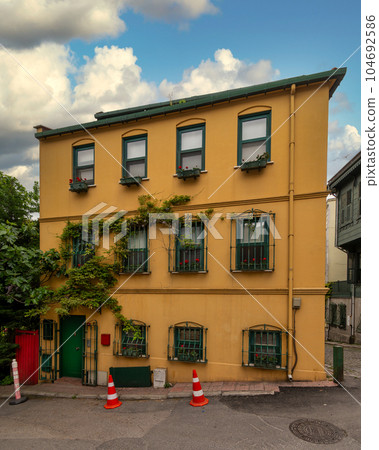 House with walls painted in orange and green, and wrought iron window, at a narrow street, Uskudar, Istanbul, Turkey 104692586