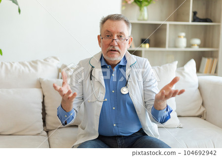 Senior man doctor talk on video call have consultation with patient look at camera webcam. Professional senior mature healthcare expert examining patient online. Healthcare concept. Webcamera view Senior man doctor talk on video call have consultation with patient look at camera webcam. Professional senior mature healthcare expert examining patient online. Healthcare concept. Webcamera view 104692942