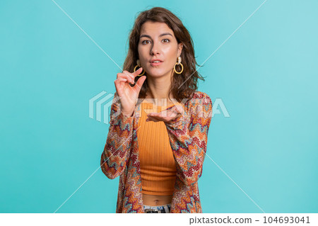 Woman showing a little bit gesture with sceptic smile showing minimum sign measuring small size 104693041