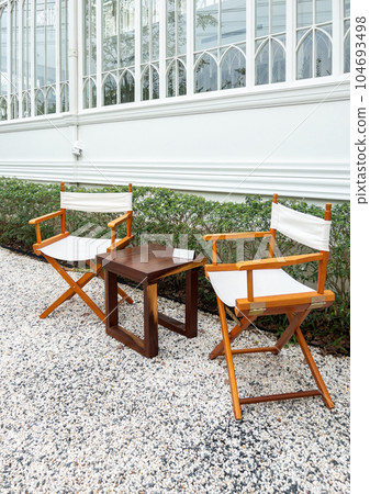 The wooden chair and table are set for coffee time. The wooden chair and table are set for coffee time. 104693498