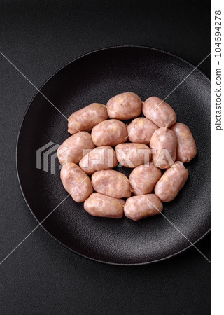 Fresh raw sausages from pork or chicken with salt, spices and herbs Fresh raw sausages from pork or chicken with salt, spices and herbs 104694278