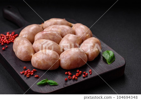 Fresh raw sausages from pork or chicken with salt, spices and herbs Fresh raw sausages from pork or chicken with salt, spices and herbs 104694348