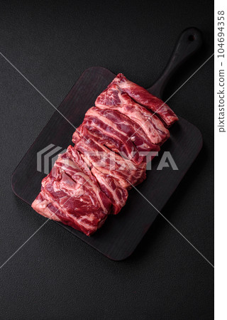 Fresh raw beef ribs with salt, spices and herbs 104694358