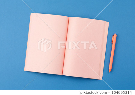 Open notepad with pen on blue background Open notepad with pen on blue background 104695314