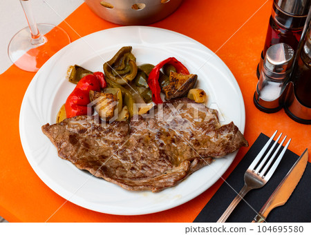 Beef entrecote with stewed vegetables and bell peppers closeup 104695580