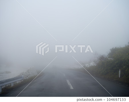The road where you can't see the destination wrapped in thick fog The road where you can't see the destination wrapped in thick fog 104697133