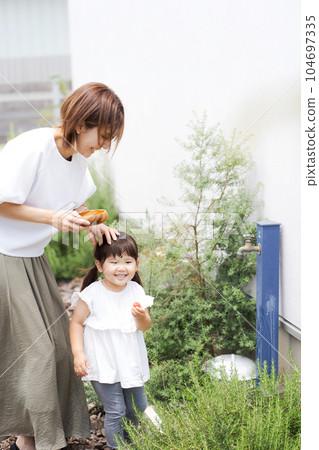 A picture of a parent and child washing cherry tomatoes 104697335