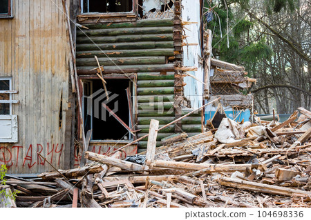 Fragment of the broken wall of an old wooden house Fragment of the broken wall of an old wooden house 104698336