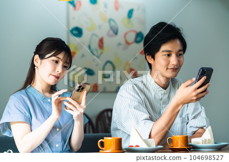約會期間專注於智能手機的情侶 約會期間專注於智能手機的情侶 104698527