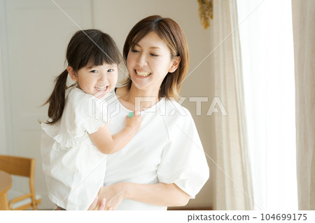 photo of girl being hugged by mom 104699175
