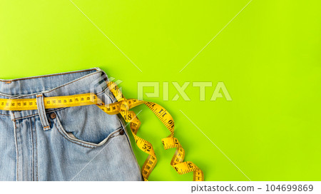 Planning for dieting healthy. Measure tape around waist jean for diet health. 104699869
