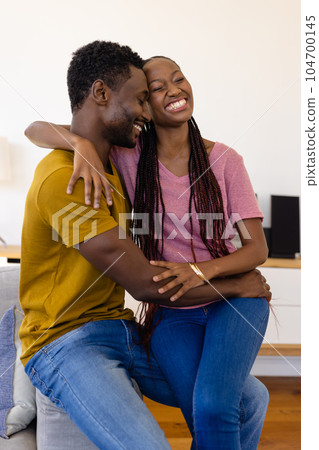 Happy african american couple embracing in living room 104700145