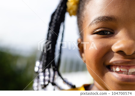 Half portrait of happy african american girl on sunny terrace 104700574