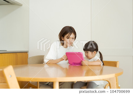 Parent and child seeing tablet 104700699