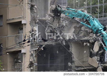 Aged public housing to be demolished Work scene of dismantling with a large heavy machine 104700706