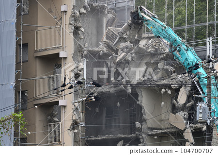 Aged public housing to be demolished Work scene of dismantling with a large heavy machine 104700707