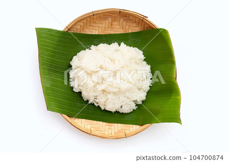 Sticky rice on banana leaf in bamboo weave plate on white background. 104700874