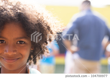 Portrait of smiling african american elementary schoolboy in school playground, copy space 104700977