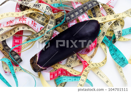Eggplant with measuring tape on white background. 104701511