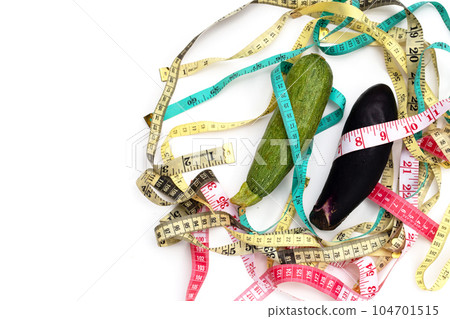 Zucchini and eggplant with measuring tape on white background 104701515