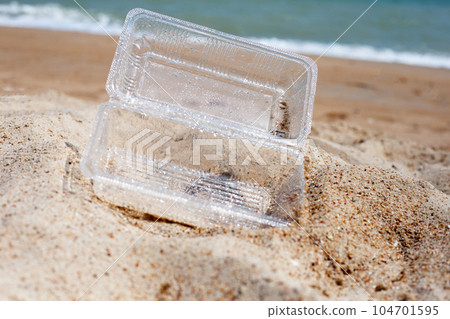 Plastic food container on the beach Plastic food container on the beach 104701595