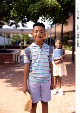 Portrait of happy african american schoolboy standing in school yard Portrait of happy african american schoolboy standing in school yard 104701892