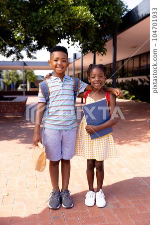 Portrait of happy african american schoolchildren standing in school yard 104701933
