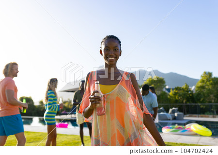 Portrait of happy african american woman dancing with her friends at party in garden Portrait of happy african american woman dancing with her friends at party in garden 104702424