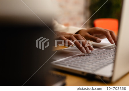 Hands of african american casual businesswoman using laptop in office 104702868