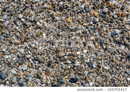 Crushed stone on the seashore. Selective focus on object. The stones were laid on the ground in the garden as a background. Background blur. Pebble stones background. Crushed stone on the seashore. Selective focus on object. The stones were laid on the ground in the garden as a background. Background blur. Pebble stones background. 104703427