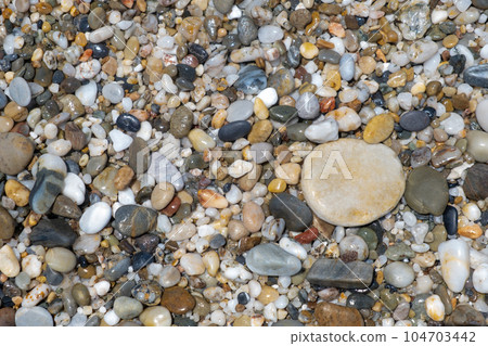 Crushed stone on the seashore. Selective focus on object. The stones were laid on the ground in the garden as a background. Background blur. Pebble stones background. Crushed stone on the seashore. Selective focus on object. The stones were laid on the ground in the garden as a background. Background blur. Pebble stones background. 104703442
