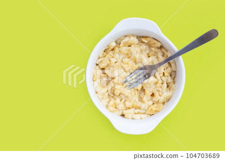 Mashed bananas in bowl on green background. 104703689