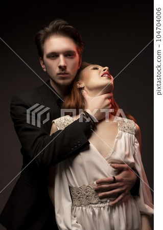 Vampire man strangling woman in dark room Vampire man strangling woman in dark room 104704006