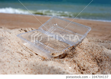 Plastic food container on the beach Plastic food container on the beach 104704137