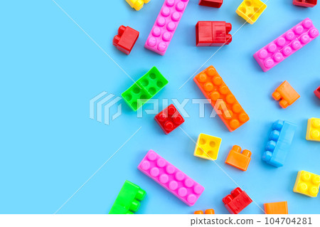 Plastic building blocks on blue background. 104704281
