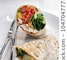 Breaded Chicken Tortilla Wrap cut in half serving on white plate at homemade gourmet restaurant, food advertising backgrounds 104704777