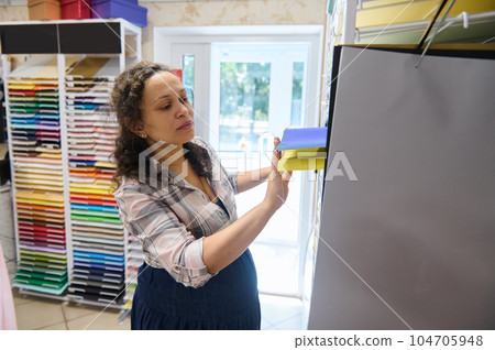 African American pregnant woman chooses color paper for design, pastel drawing or watercolor painting in stationary shop African American pregnant woman chooses color paper for design, pastel drawing or watercolor painting in stationary shop 104705948