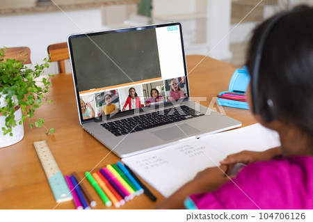 Multiracial girl and students attending online class over video call on laptop at home, copy space 104706126