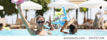 Smiling woman in sunglasses holding pink flexible sticks for aerobics 104707206