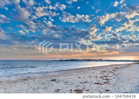 Seascape view of nature on the coast of a beach, and ocean water on a sunny summer day. Beautiful scenery of a sea shore filled with sand and a cloudy blue sky over the horizon with tide and current 104708416