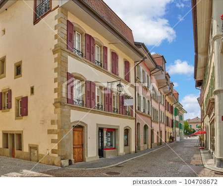 Street view of old buildings in a historic city with built medieval architecture and a cloudy blue sky in Annecy, France. Beautiful landscape of an empty small urban town with homes or houses Street view of old buildings in a historic city with built medieval architecture and a cloudy blue sky in Annecy, France. Beautiful landscape of an empty small urban town with homes or houses 104708672