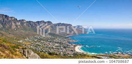 Landscape mountain panorama, sea and coastal city with residential buildings in famous travel or tourism destination. Copy space and scenic Twelve Apostles with blue sky in Cape Town, South Africa 104708687