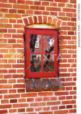 Dirty window in an old red brick house outside. Background of an architectural built structure on an exterior wall with red wooden windowpanes shut close. Historic building in a traditional town Dirty window in an old red brick house outside. Background of an architectural built structure on an exterior wall with red wooden windowpanes shut close. Historic building in a traditional town 104709360