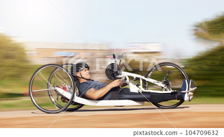 Cycling, fitness and speed with man and handcycle in nature for training, sports and challenge. Exercise, workout and motion blur with person with a disability in park for cardio and health Cycling, fitness and speed with man and handcycle in nature for training, sports and challenge. Exercise, workout and motion blur with person with a disability in park for cardio and health 104709632
