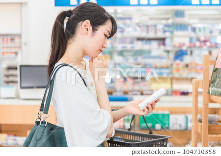 Asian woman shopping for moisturizing lotion/body cream at pharmacy/drugstore Asian woman shopping for moisturizing lotion/body cream at pharmacy/drugstore 104710358