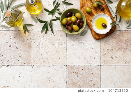 Olives and olive oil in a bottle, background with copy space, top view 104713530